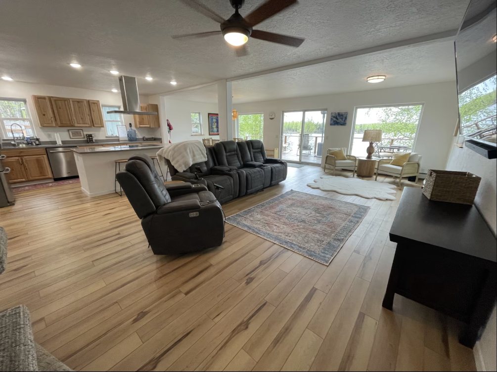 Open-plan living room, kitchen and lake-view windows at Dockside Dreams
